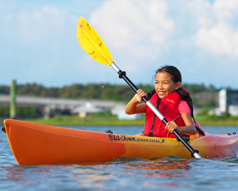 Kid paddling in the Old Town Ocean Kayak Banzai kayak with the Saber paddle