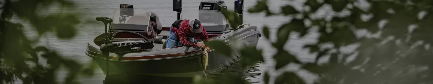 Angler bringing in a bass on a boat with Ultrex and Talon